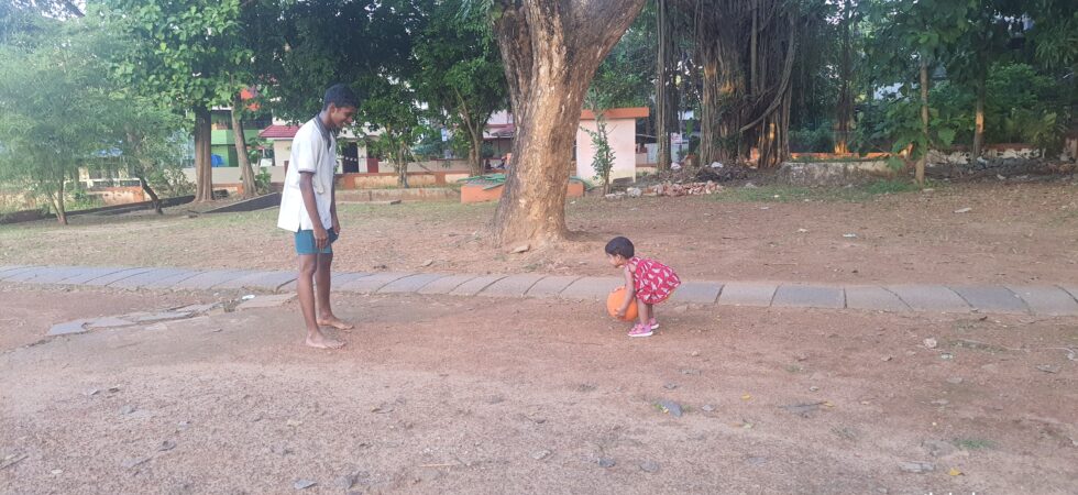 A very young child playing with another child.